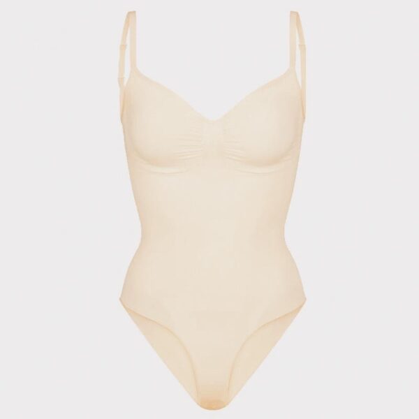 Cream Contour Essentials Bodysuit with seamless design, sculpting support, and adjustable straps, perfect for layering under light fabrics or wearing alone.