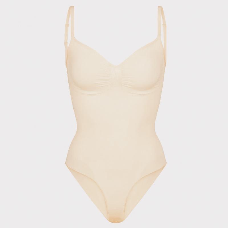 Cream Contour Essentials Bodysuit with seamless design, sculpting support, and adjustable straps, perfect for layering under light fabrics or wearing alone.